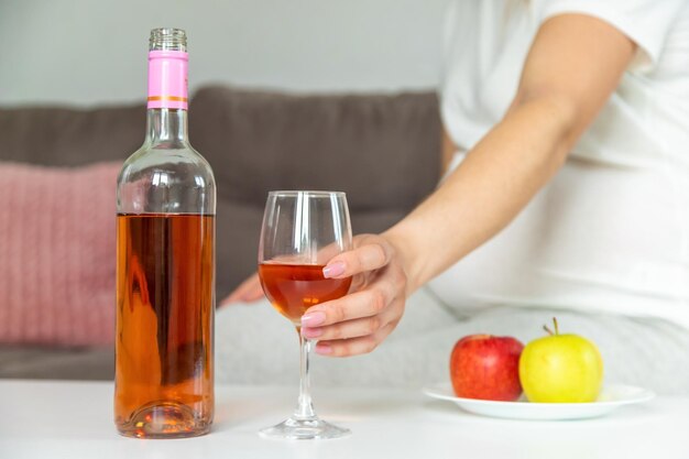 A pregnant woman drinks wine in a glass Selective focus