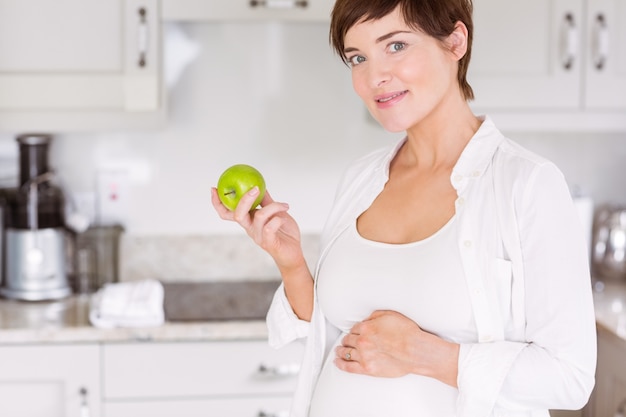 Donna incinta che mangia una mela