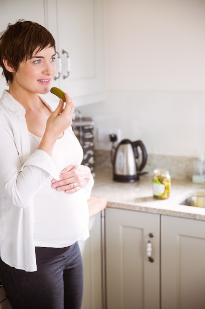 Беременная женщина есть банку соленья