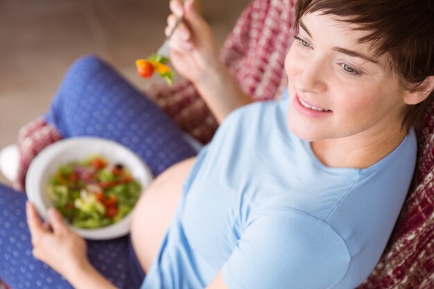 Foto donna incinta che mangia un'insalata