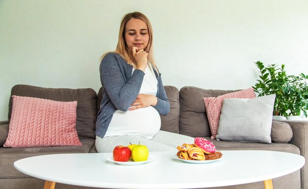 A pregnant woman eats a sweet donut Selective focus