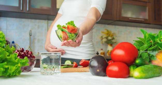 A pregnant woman eats vegetables and fruits