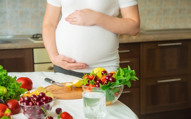 Photo a pregnant woman eats vegetables and fruits