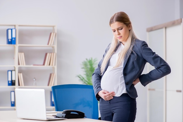 Pregnant woman employee in the office