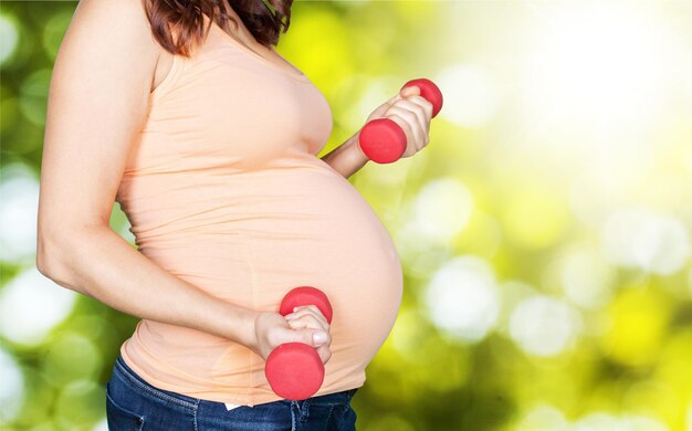 Pregnant woman exercising the biceps with dumbbells