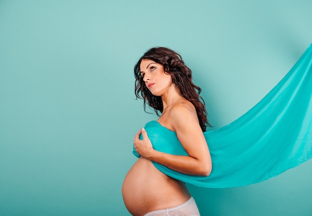 Беременная женщина, ожидающая ребенка, ласкает живот