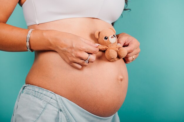 Pregnant woman expecting a child caresses her belly