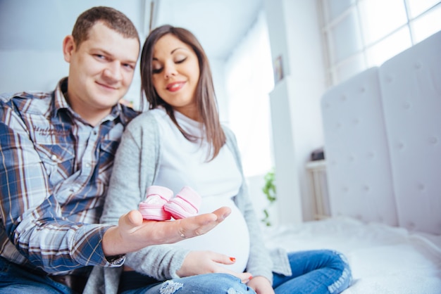 Pregnant woman and her husband holding booties