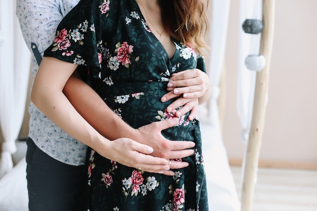 Pregnant woman and her husband holding hand together