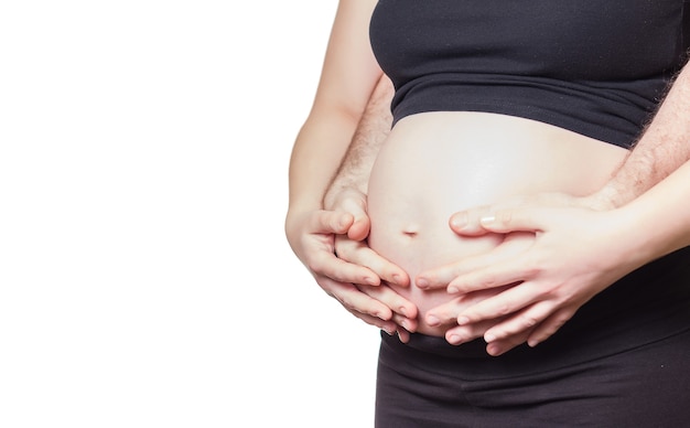 Pregnant woman and her husband touching the belly