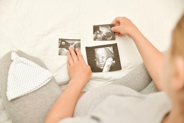 Pregnant woman holding 4D ultrasound image Expectation of a child