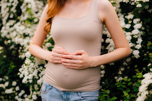 Pregnant woman holding belly with hands