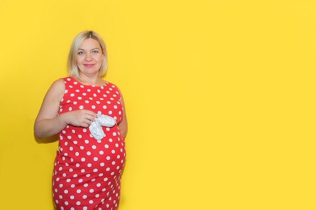 Pregnant woman holding booties on her belly