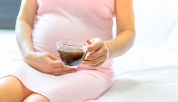 Pregnant woman holding a cup of coffee