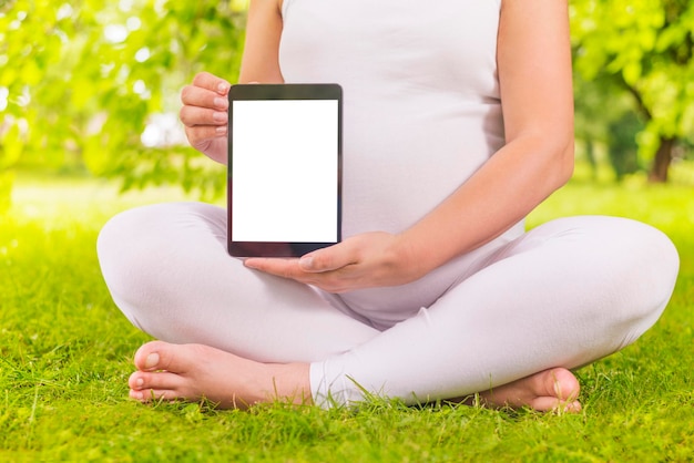 Pregnant woman holding digital tablet