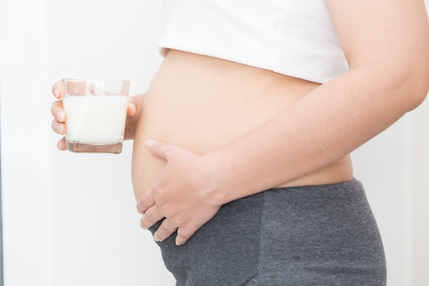 Pregnant woman holding a glass of fresh milk