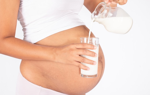 Foto donna incinta che tiene un bicchiere di latte fresco