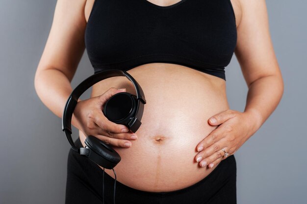 Pretty Pregnant Woman Putting Headphones On Her Belly Stock Photo, Picture  and Royalty Free Image. Image 59147162.