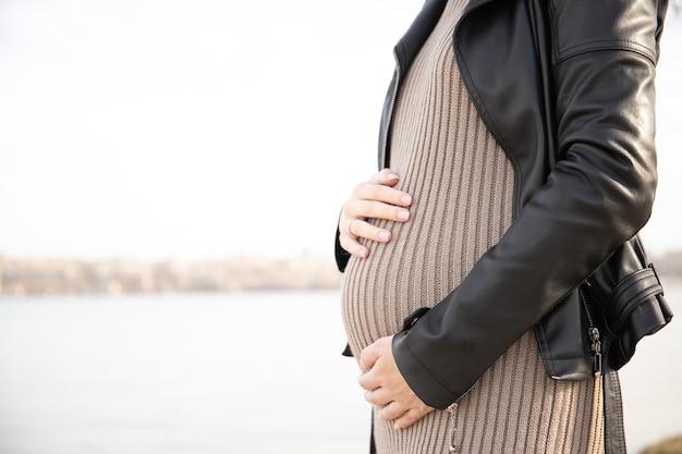 Pregnant woman holding her hands on the belly