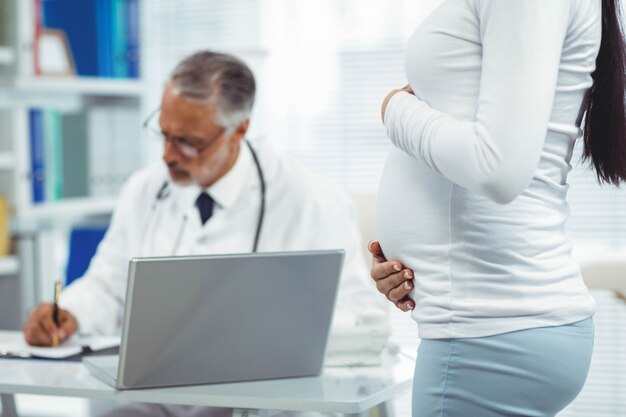 Photo pregnant woman holding her stomach in clinic