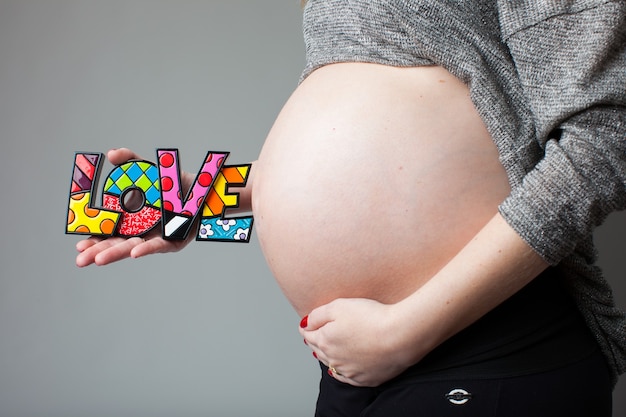 pregnant woman holding love word