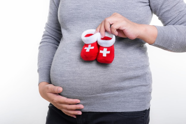 Pregnant woman holding red socks for baby