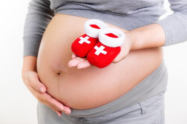 Pregnant woman holding red socks for baby