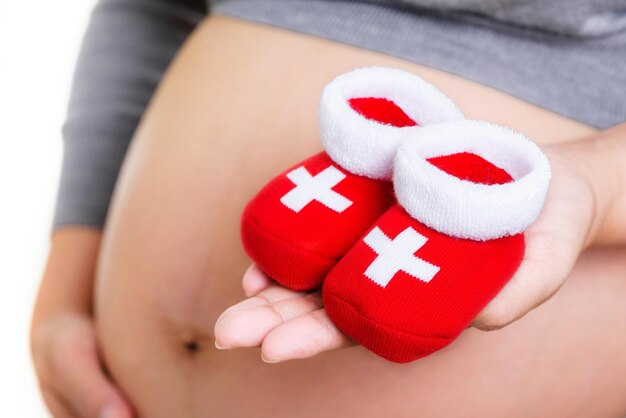 Pregnant woman holding red socks for baby