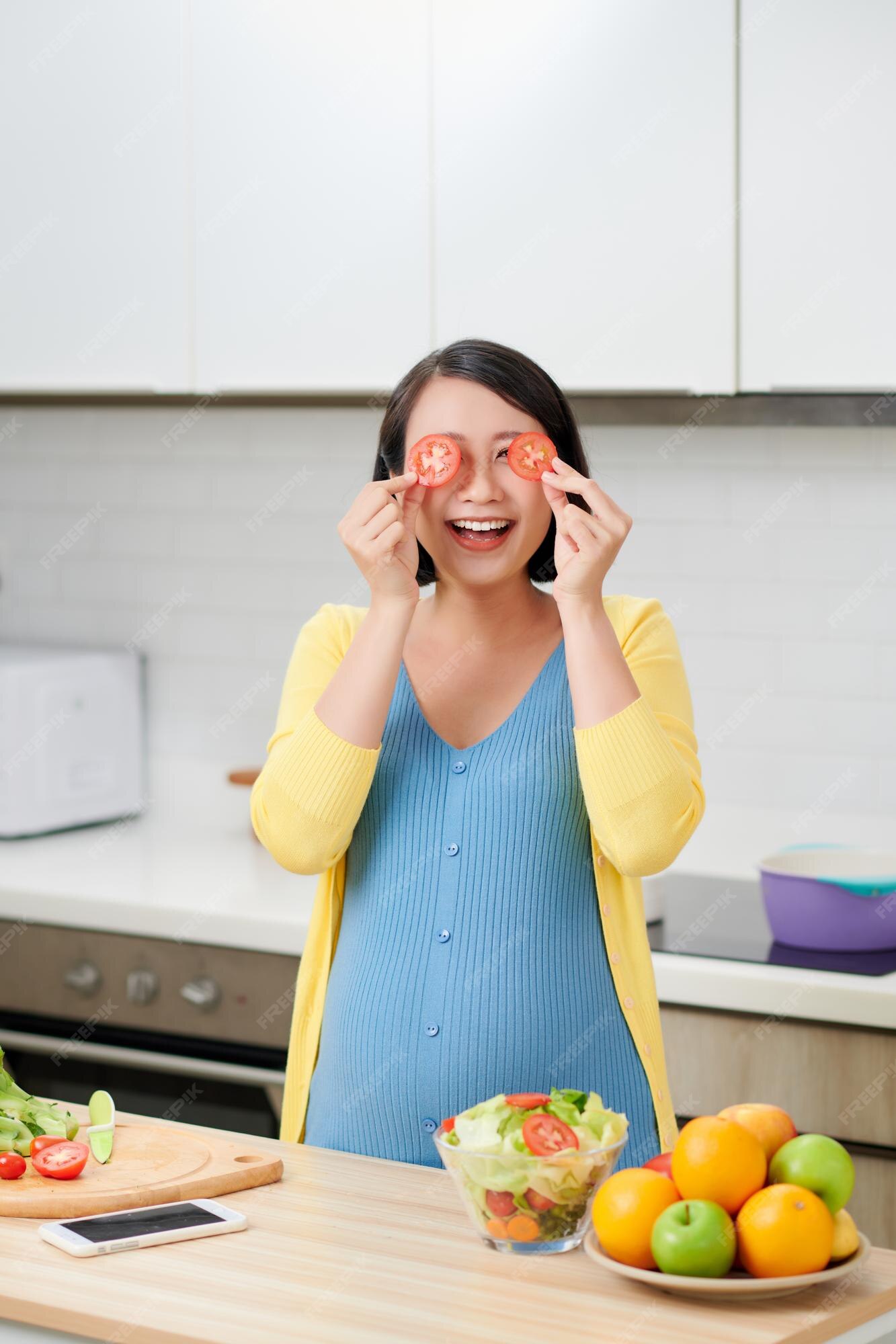 Premium Photo Pregnant woman holding sliced tomato and covering eyes