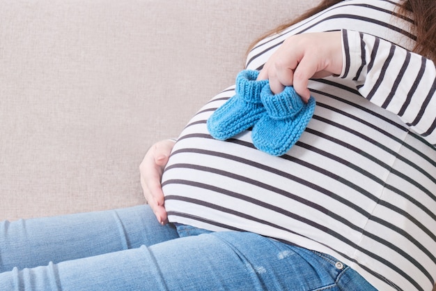 pregnant woman holding small socks for newborn