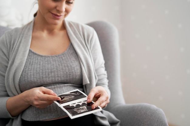 Photo pregnant woman holding ultrasound photograph