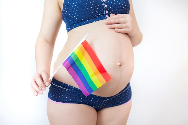 A pregnant woman holds the flag of the LGBT