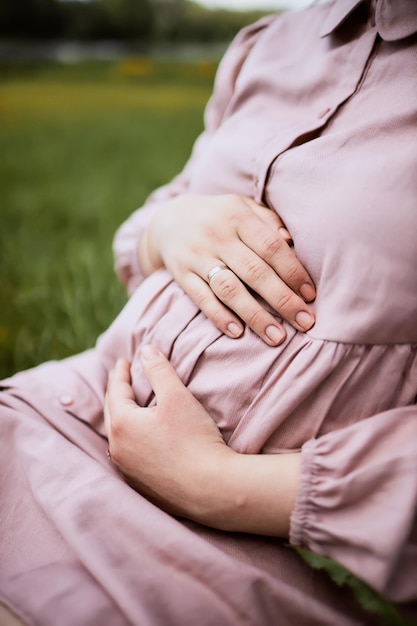 Pregnant woman hugs her belly