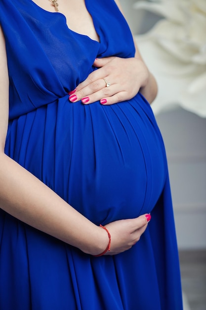 Pregnant woman hugs her belly