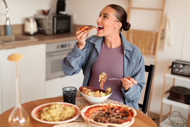 Foto donna incinta che si dedica a pizza e pasta a un pasto gioioso