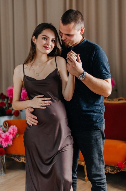 A pregnant woman is dancing with her husband