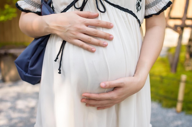 Pregnant woman is embracing her belly