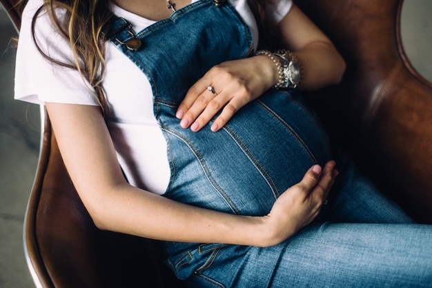 Pregnant woman is lying on the armchair