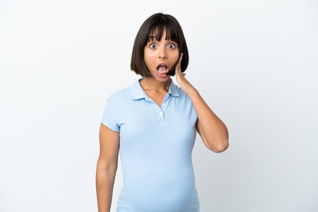 Pregnant woman over isolated white background with surprise and shocked facial expression