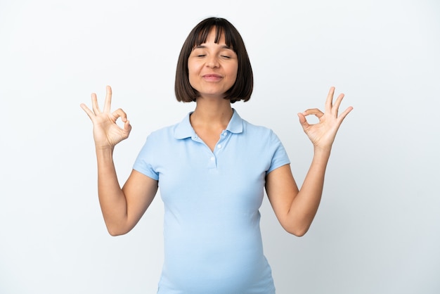 Pregnant woman over isolated white surface in zen pose