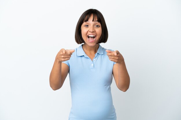 Pregnant woman over isolated white wall surprised and pointing front