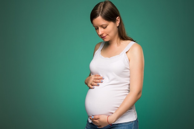 Pregnant woman looking at her belly expecting a baby 9 months time passed