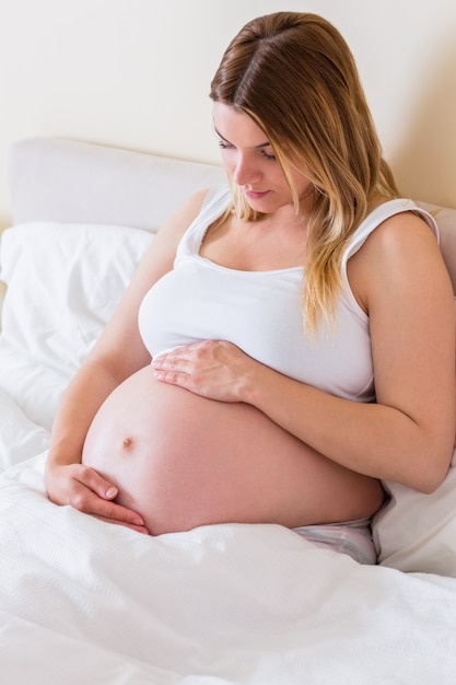 Pregnant woman looking at her belly 