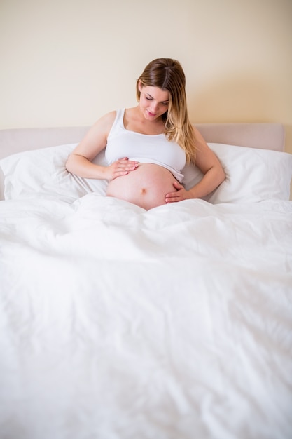 Pregnant woman looking at her belly 