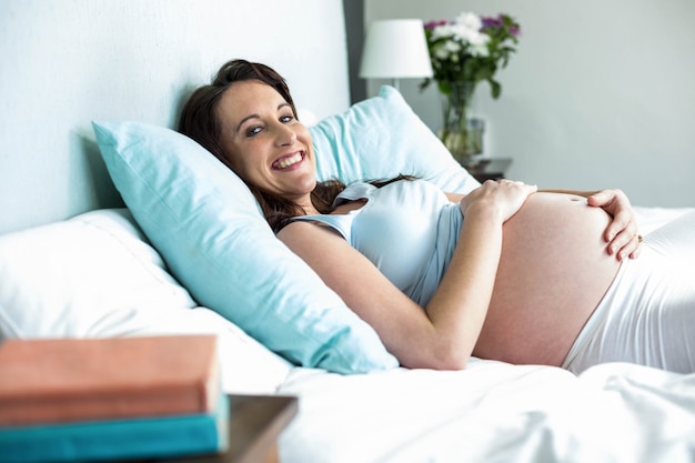 Pregnant woman lying on bed at home 