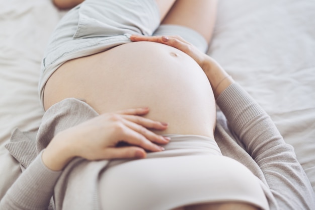 Pregnant woman lying on bed. Lifestyle