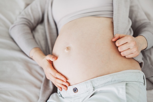 Pregnant woman lying on bed. View from above. Maternity concept.