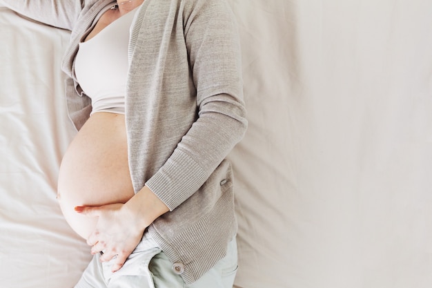 Pregnant woman lying on bed