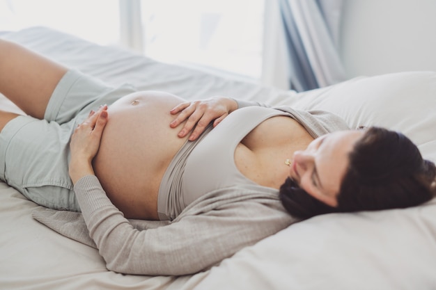 Pregnant woman lying on bed