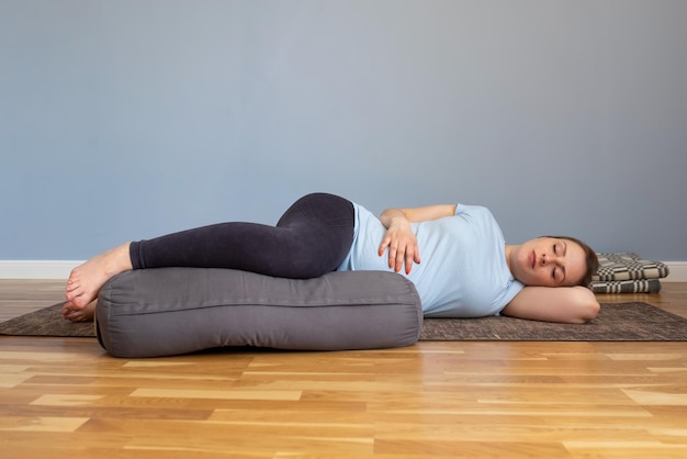 Pregnant woman lying in Shavasana resting after practice meditating breathing